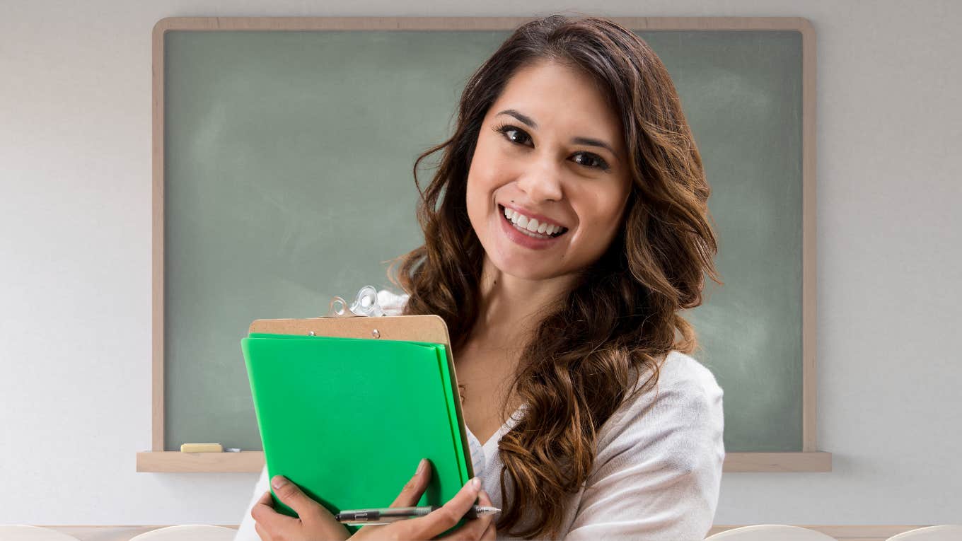 Young teacher smiling in her classroom. 