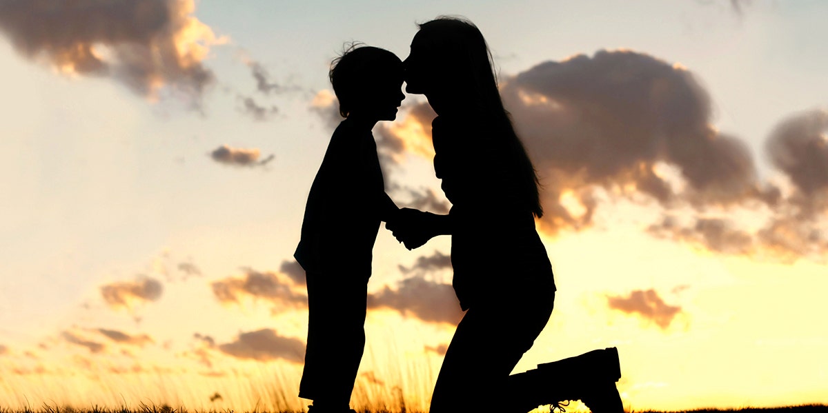 woman kissing child on forehead