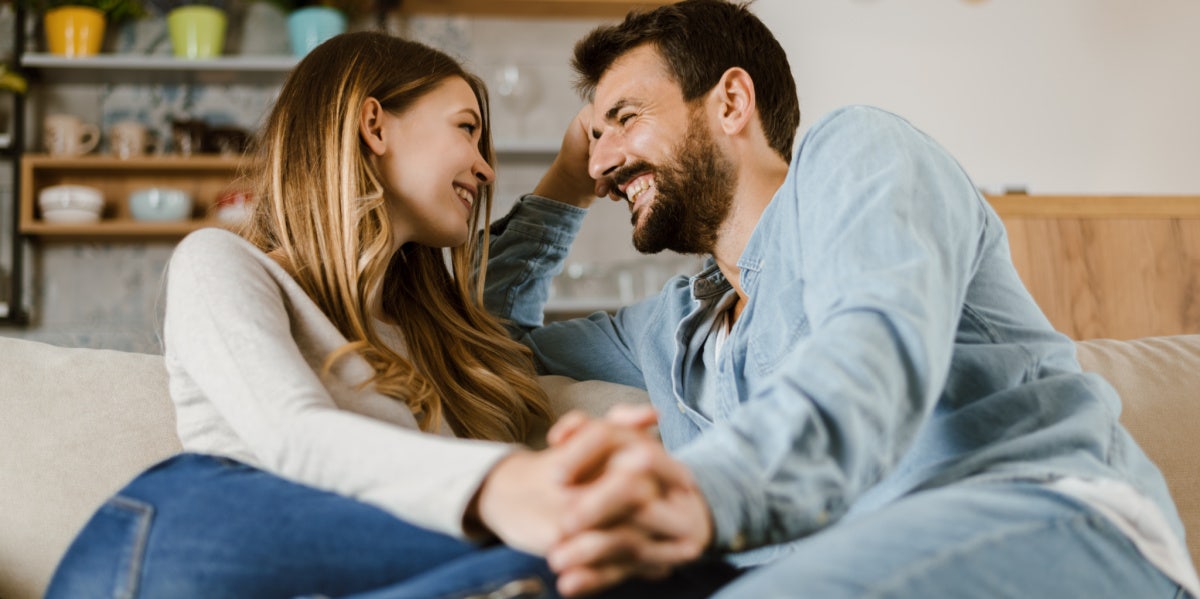 happy couple holding hands on couch