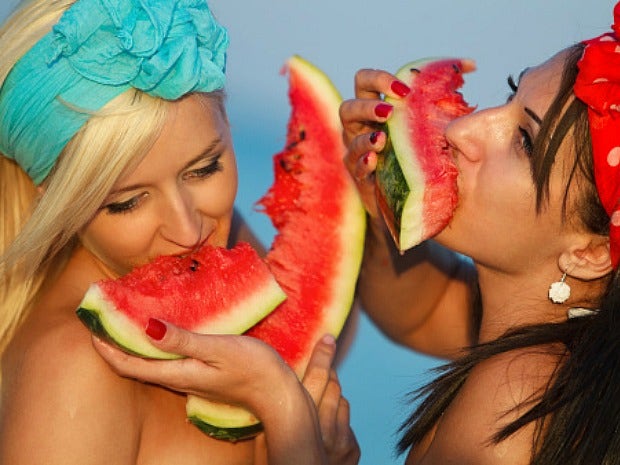 two women eating watermelon