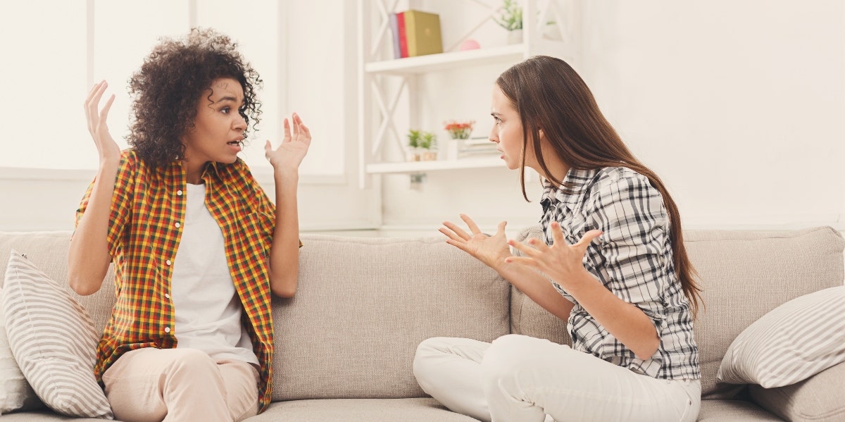 two women friends arguing on couch