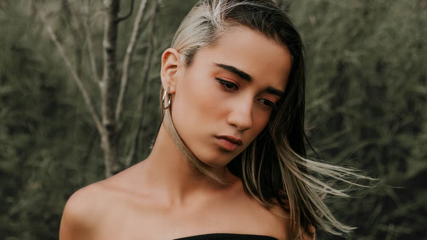 The Tiny Way To Know If Your Childhood Trauma Is Affecting You Now Woman reflecting on childhood overcome with emotions