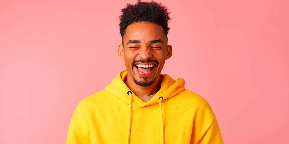 man in yellow hoodie smiling mouth open