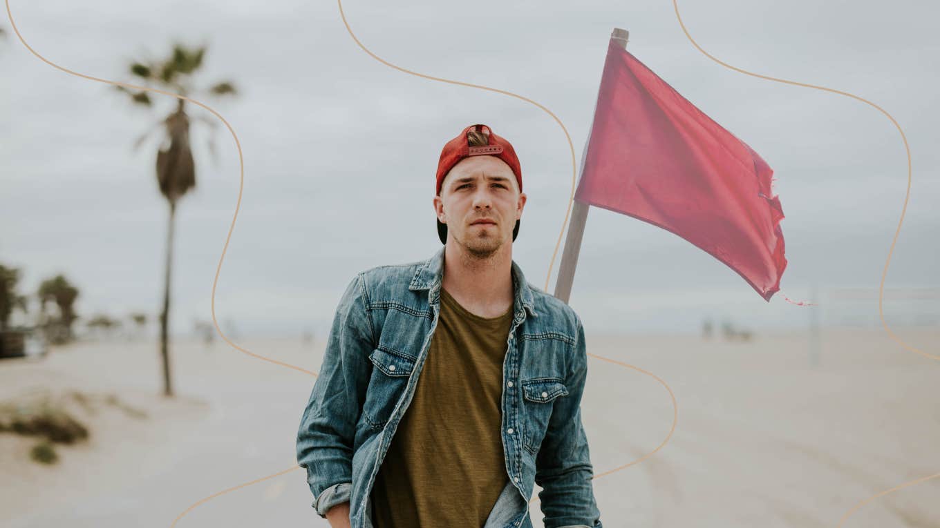 attractive man with a red flag behind him