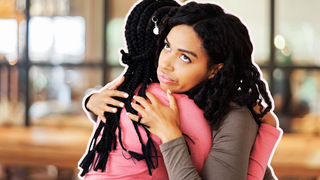 Two women hugging, rolling eyes behind her back