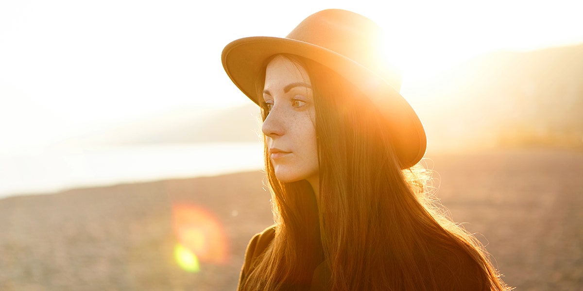 woman looking away with sun in background