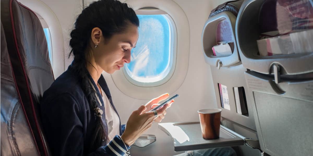 A woman is sitting on an airplane.