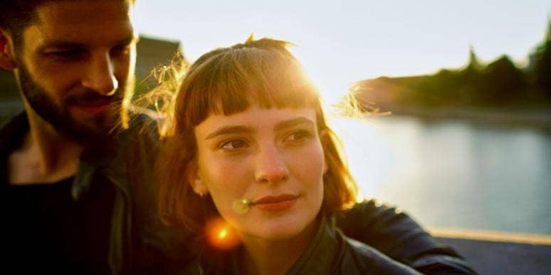 I Stayed In My Unhappy Marriage Because Of Money. That Only Hurt My Kids. woman looking off into distance with sunset behind her