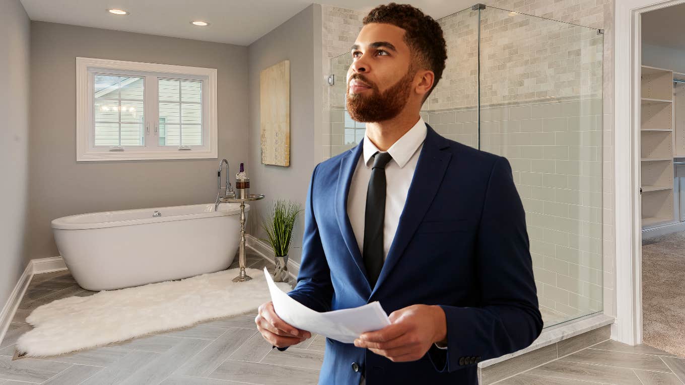 Realtor standing in a master bathroom. 