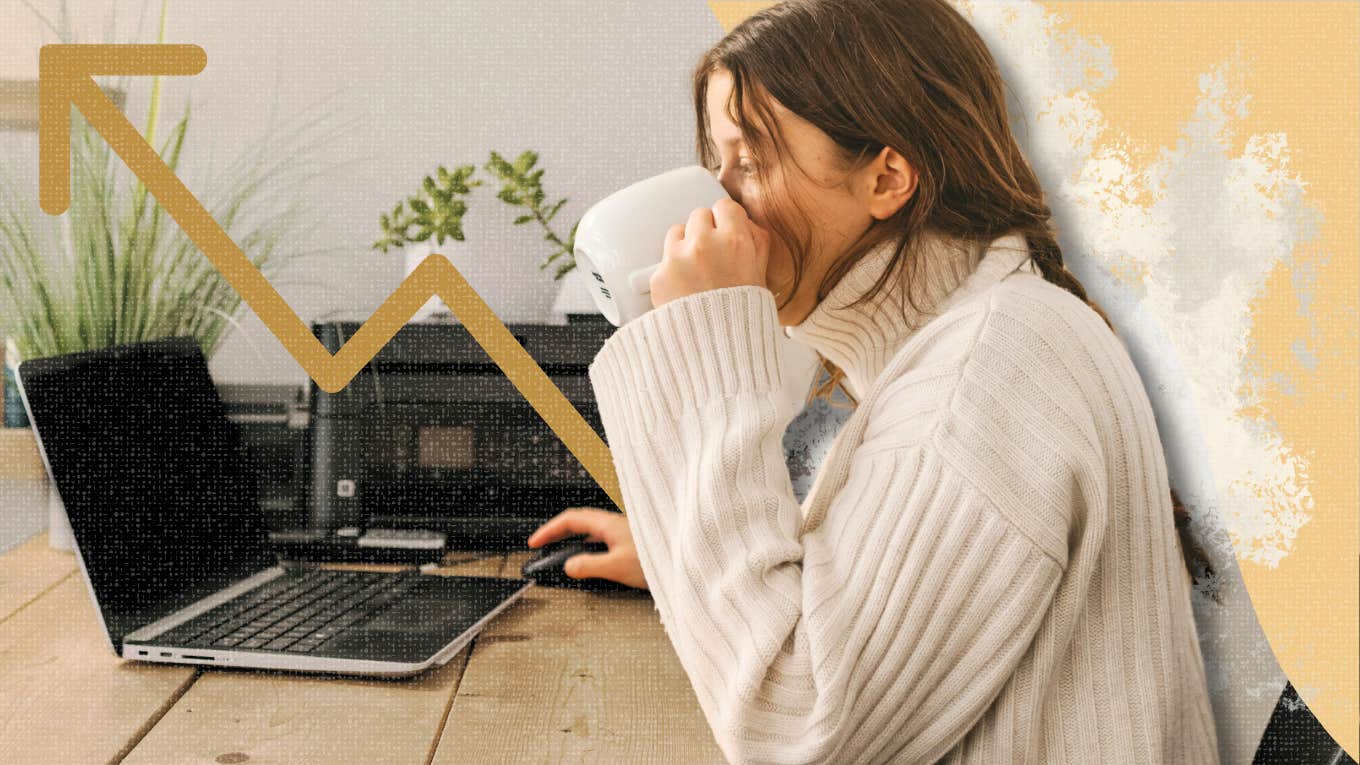 Woman drinking coffee while working at desk 