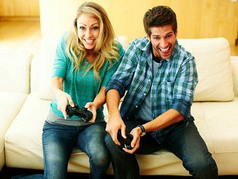 man woman playing video games on sofa
