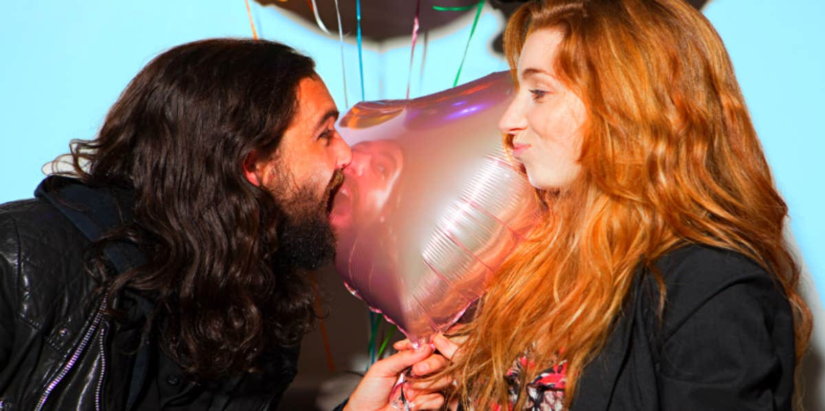 man and woman in front of heart balloon