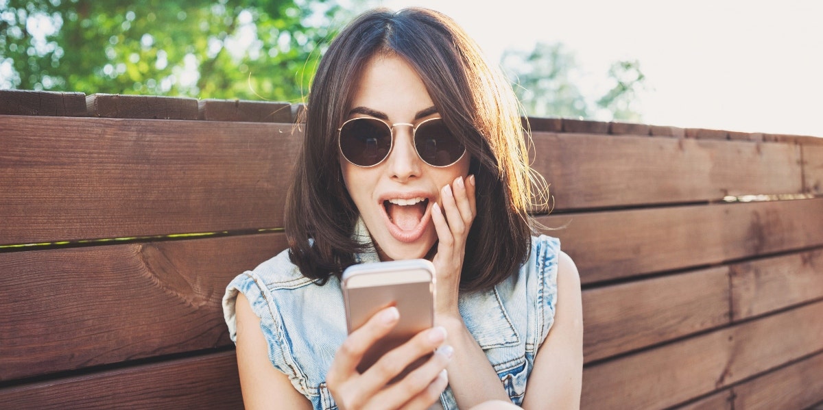 happy woman looking at her smartphone