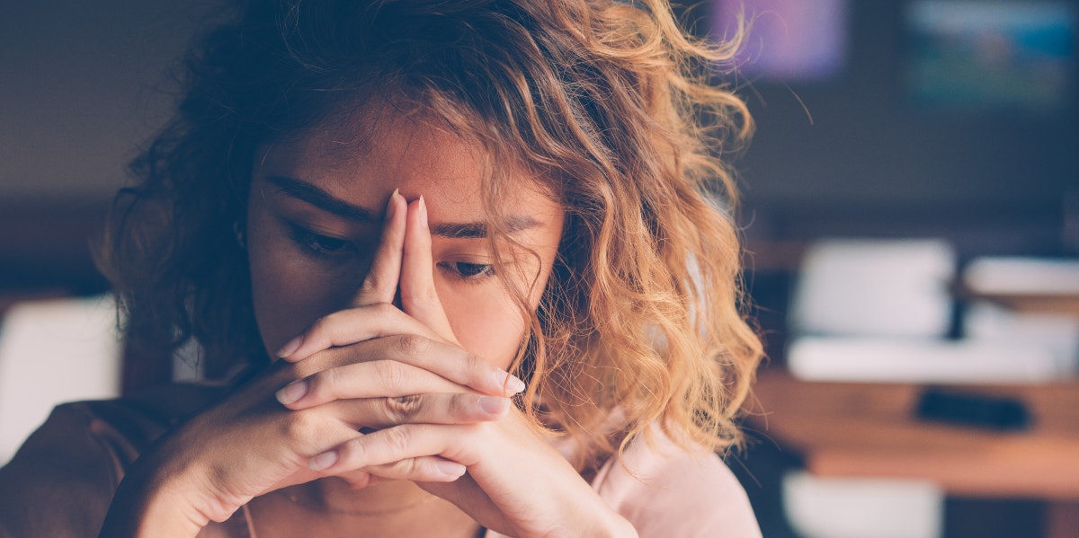 woman holding her hands in front of her face