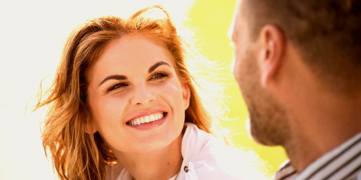 Woman smiles at man in foreground