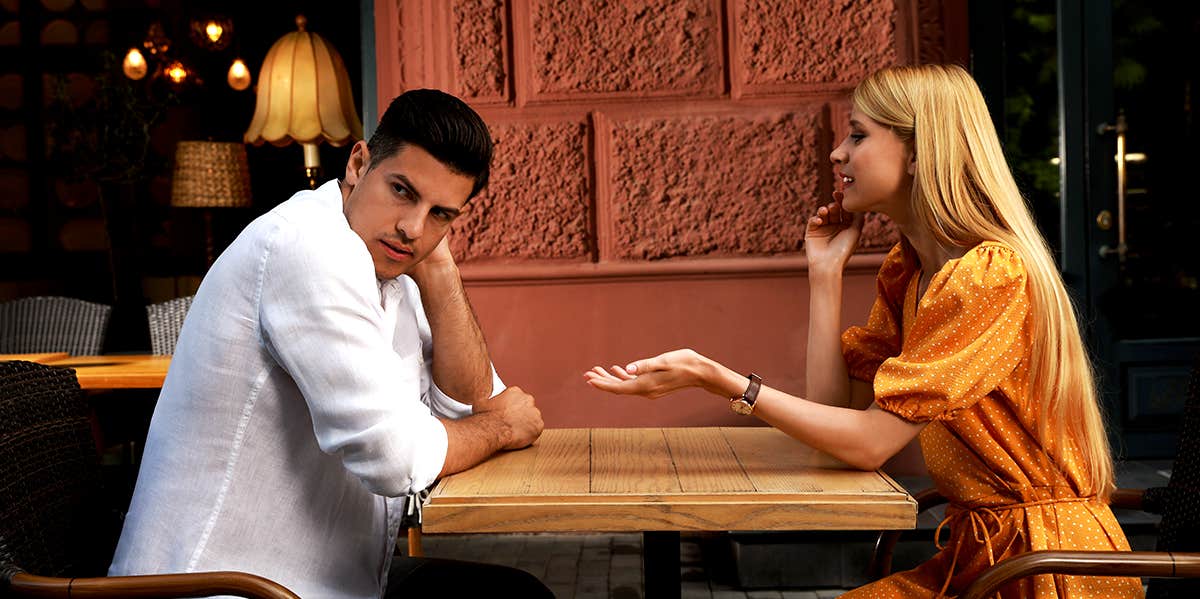 man ignoring woman talking at table