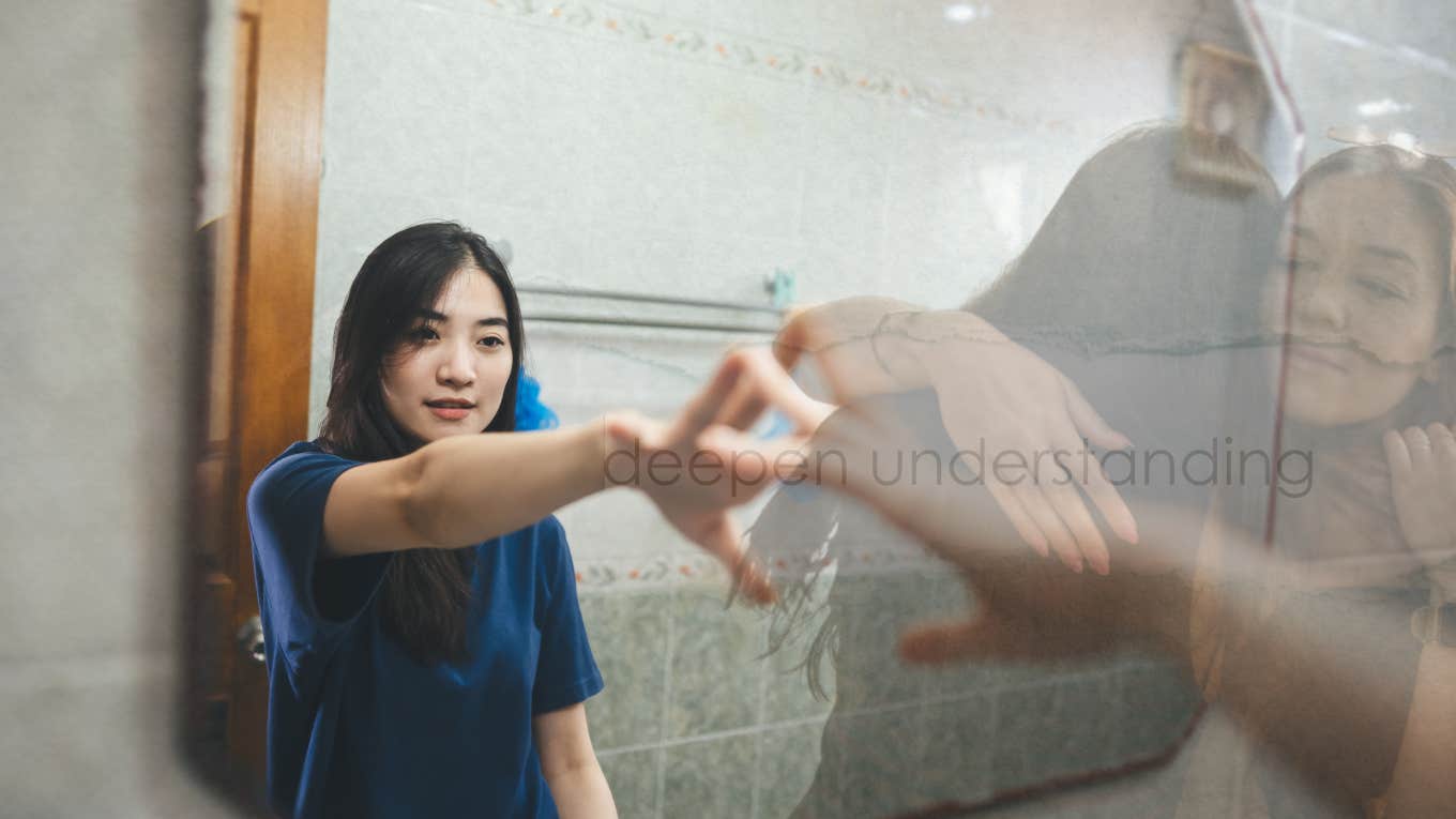 young girl reaching out in mirror- to herself, the world, her mother