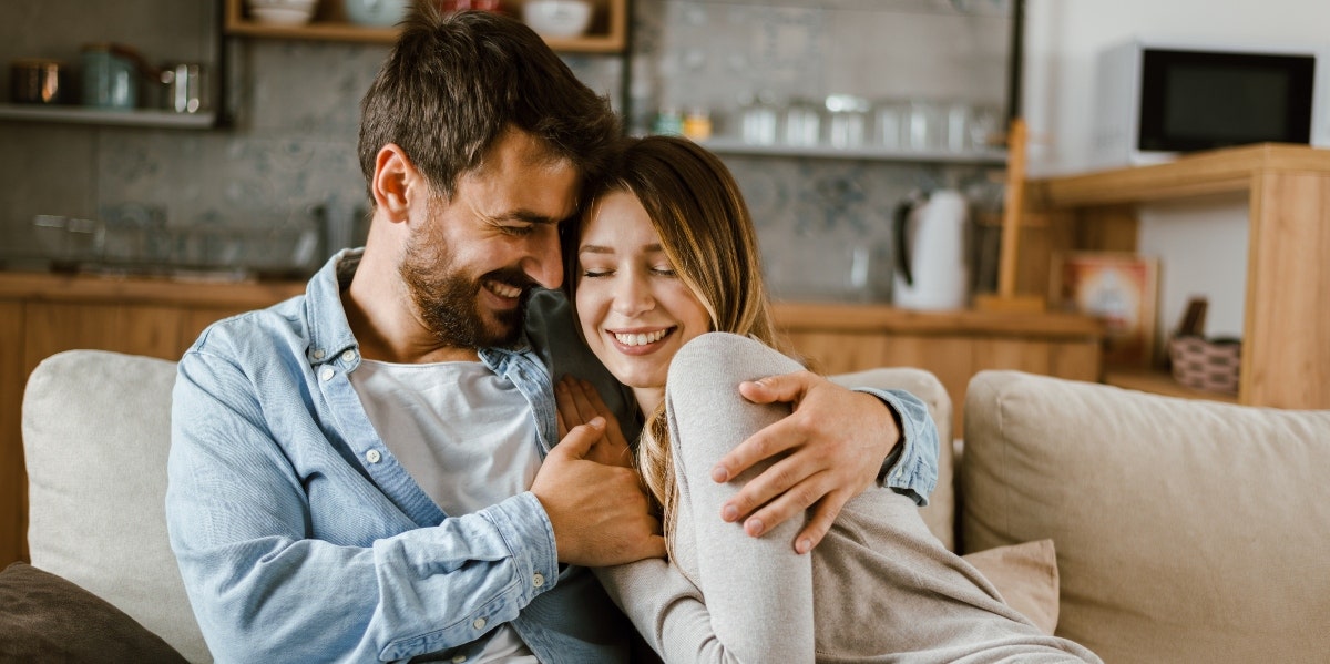 man and woman hugging on couch