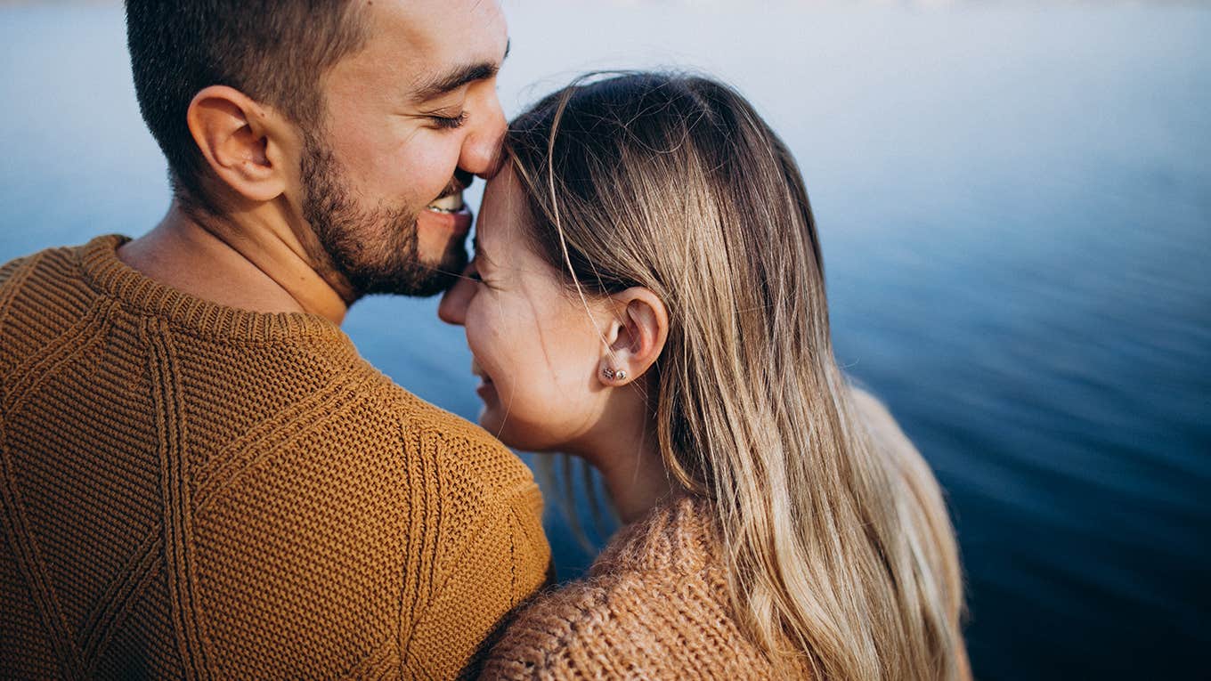 Young couple in park standing by the river