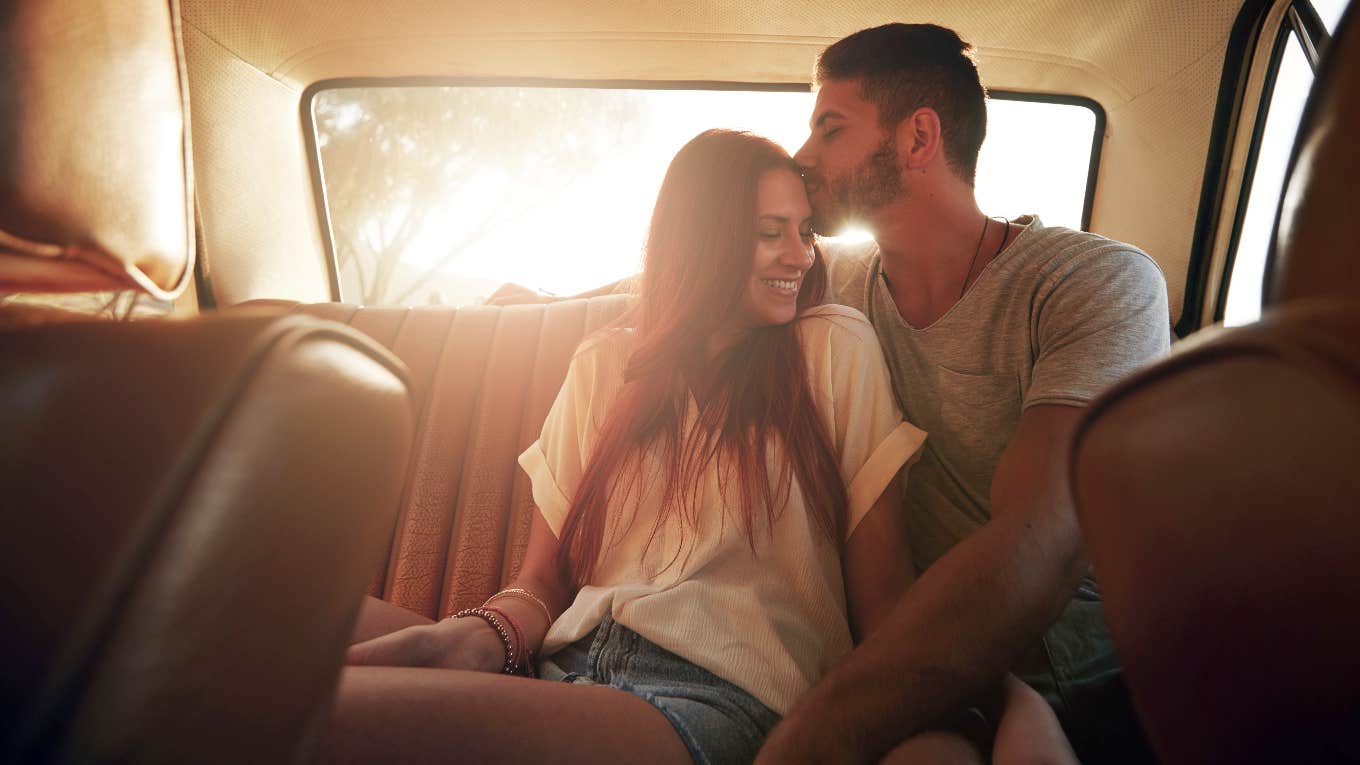 couple in car backseat snuggling