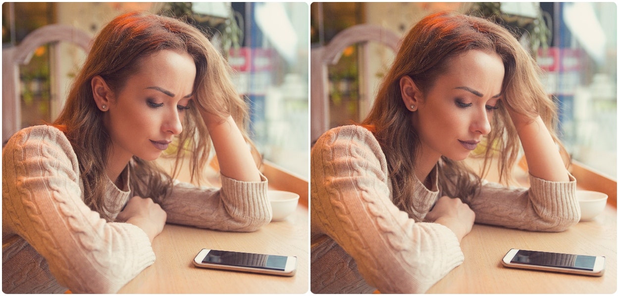 sad woman staring at phone on counter