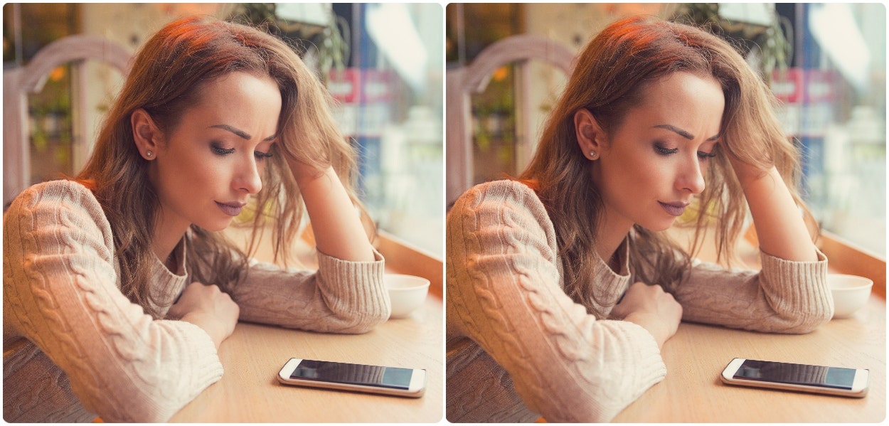 sad woman staring at phone on counter