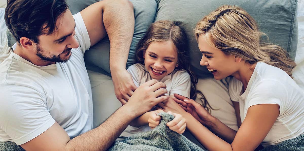 parents and kid in bed