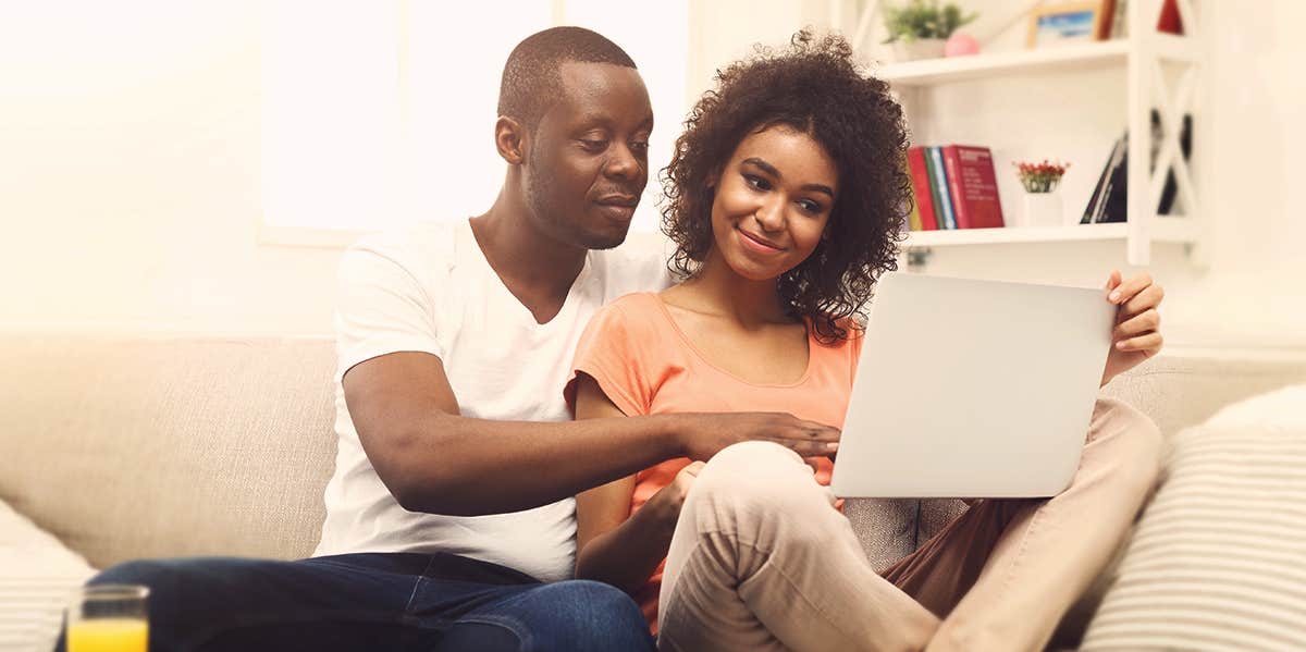 couples looking at laptop in the couch 