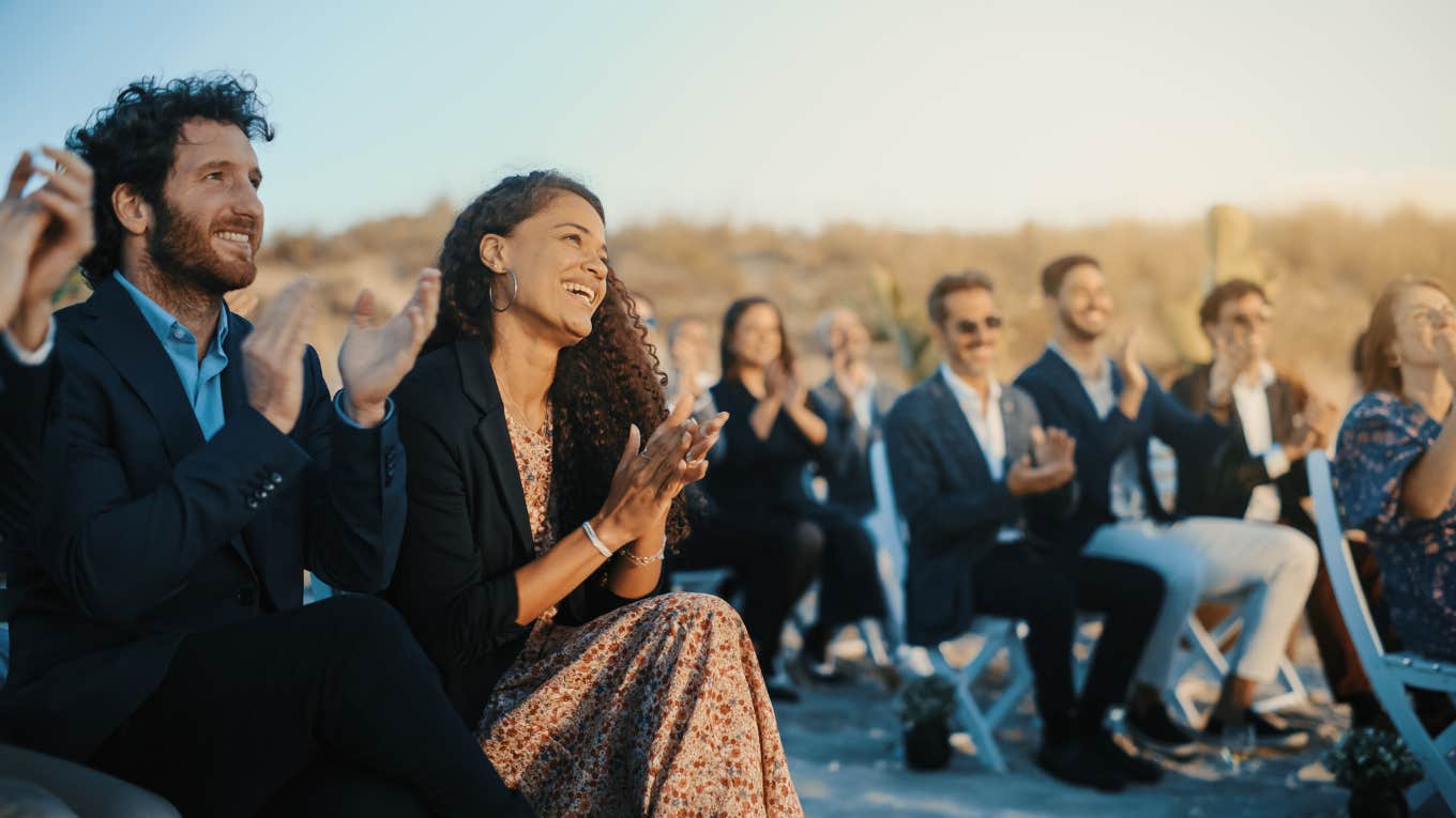 Guests Sitting in an Outdoor Venue and Clapping Hands.