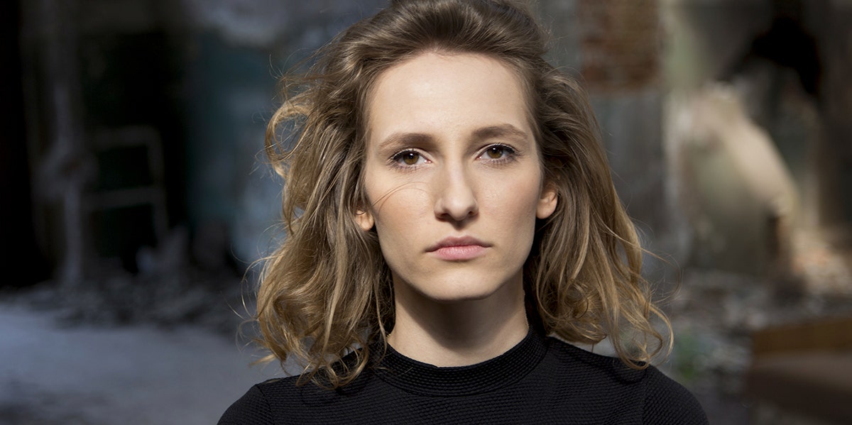 I’m A Successful Professional Who Grew Up on Welfare — And It Literally Saved My Life woman with stoic expression looking directly at camera