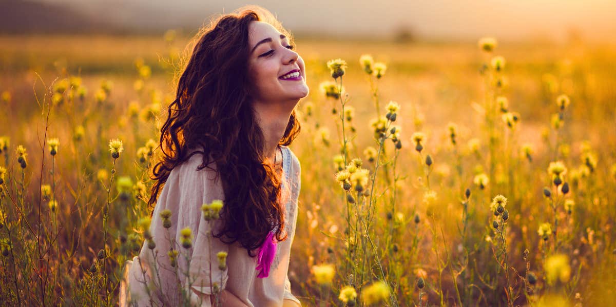 smiling girl sitting in flower field