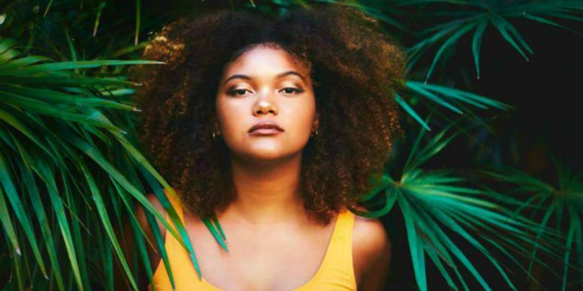 strong woman surrounded by palm trees