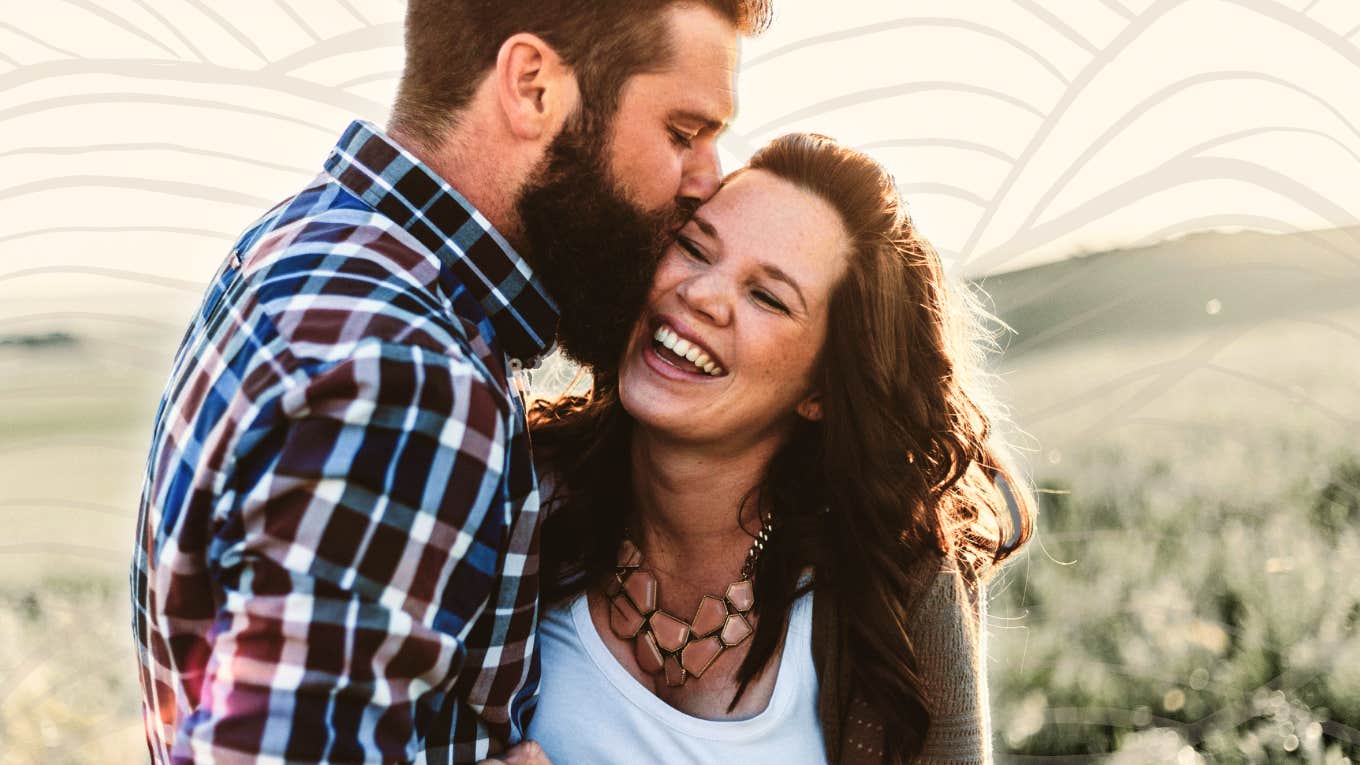 Woman being loved on by partner, smiling 