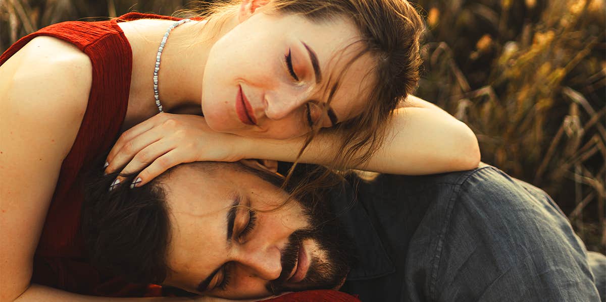 woman cuddling with man in field