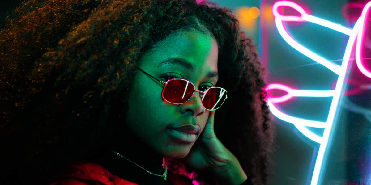 What Your Personality Type Reveals About Your Greatest Personal Weakness woman posing with neon lights