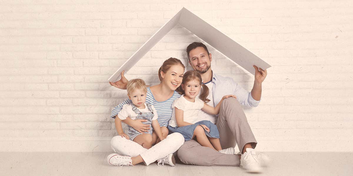 a couple and their children sitting against the wall