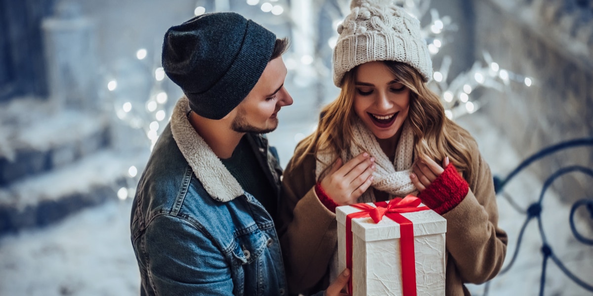 What His Holiday Gift Really Says About Your Relationship Status man giving woman gift