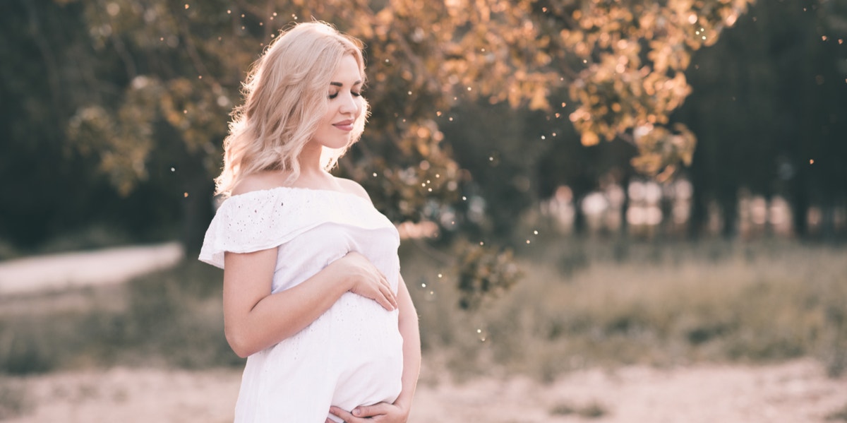 6 Things I Learned When I Visited A Witch During My Pregnancy woman cradling baby bump