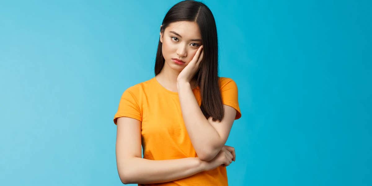 dispirited and pouting woman in marigold yellow tee shirt