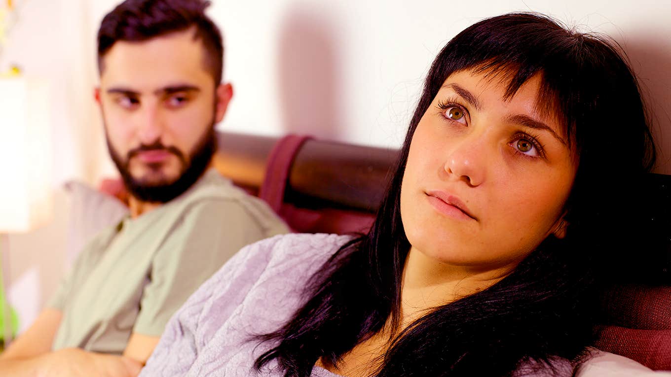 couple sitting in bed unhappy