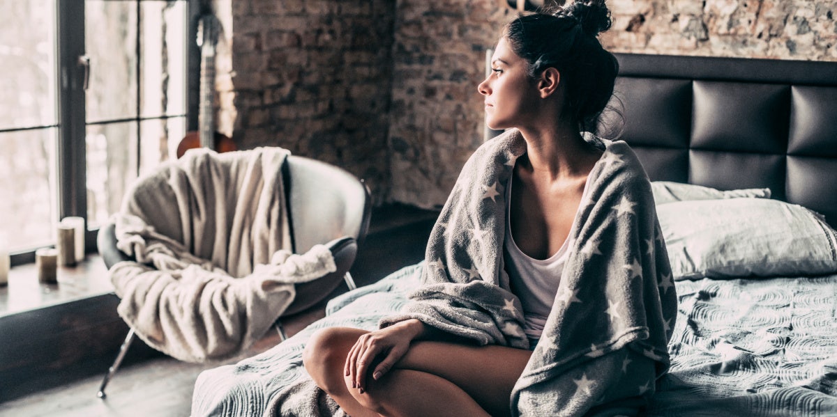 sad woman sitting alone on the bed