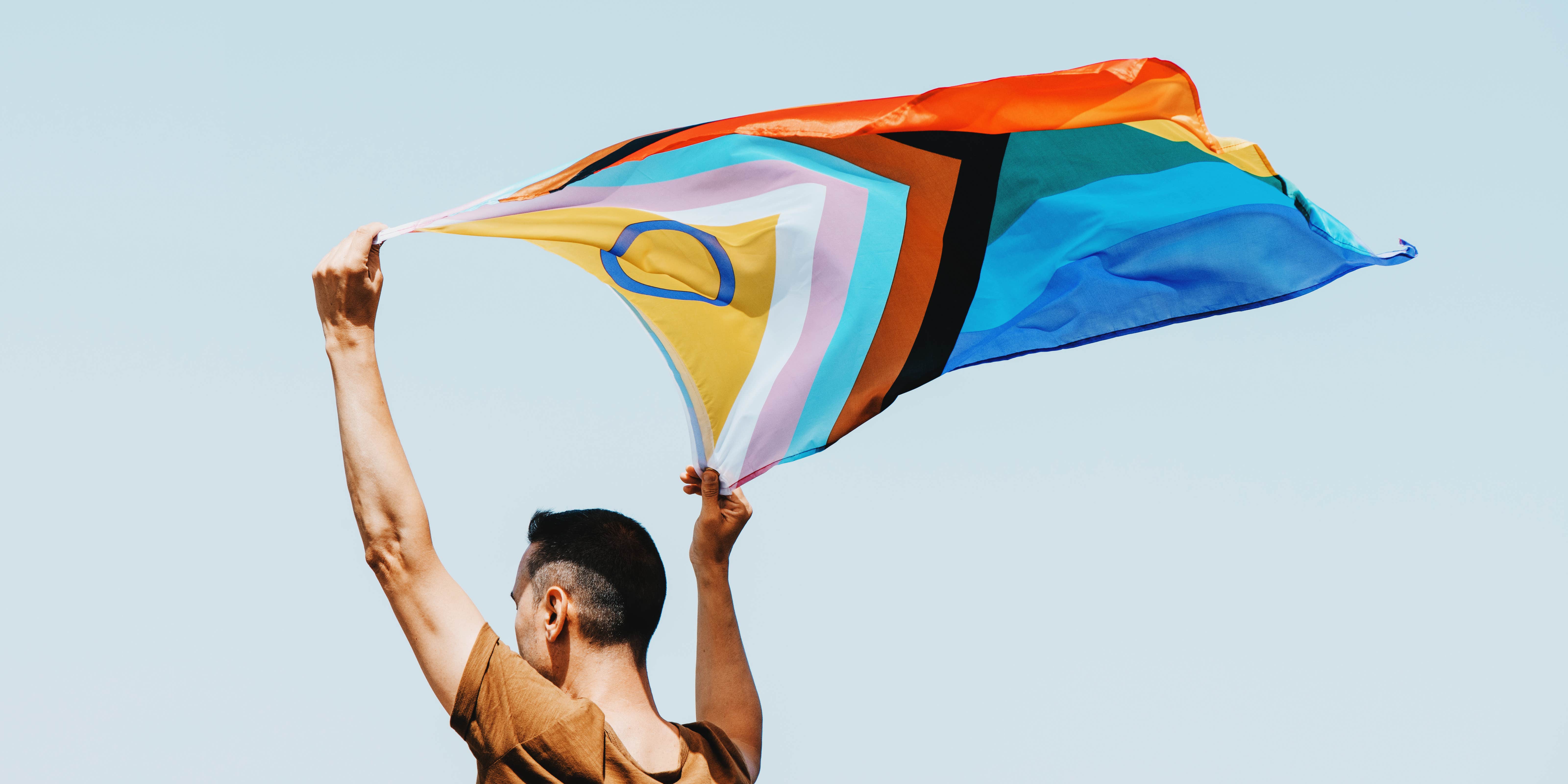 man waving an intersex pride flag