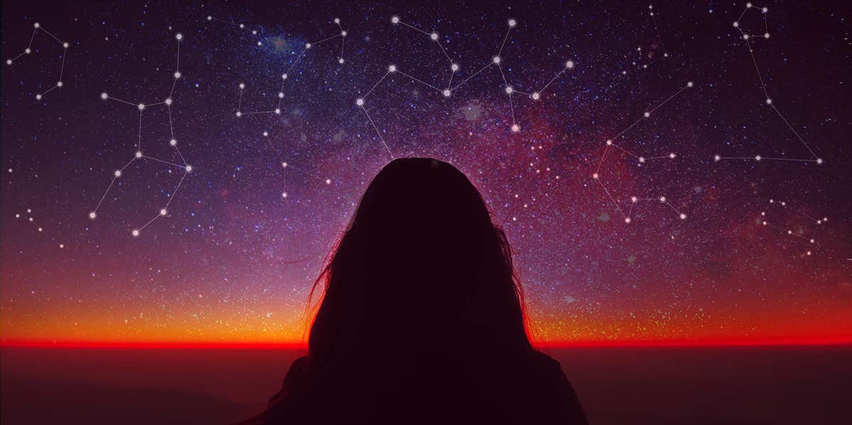 woman standing among constellations and stars
