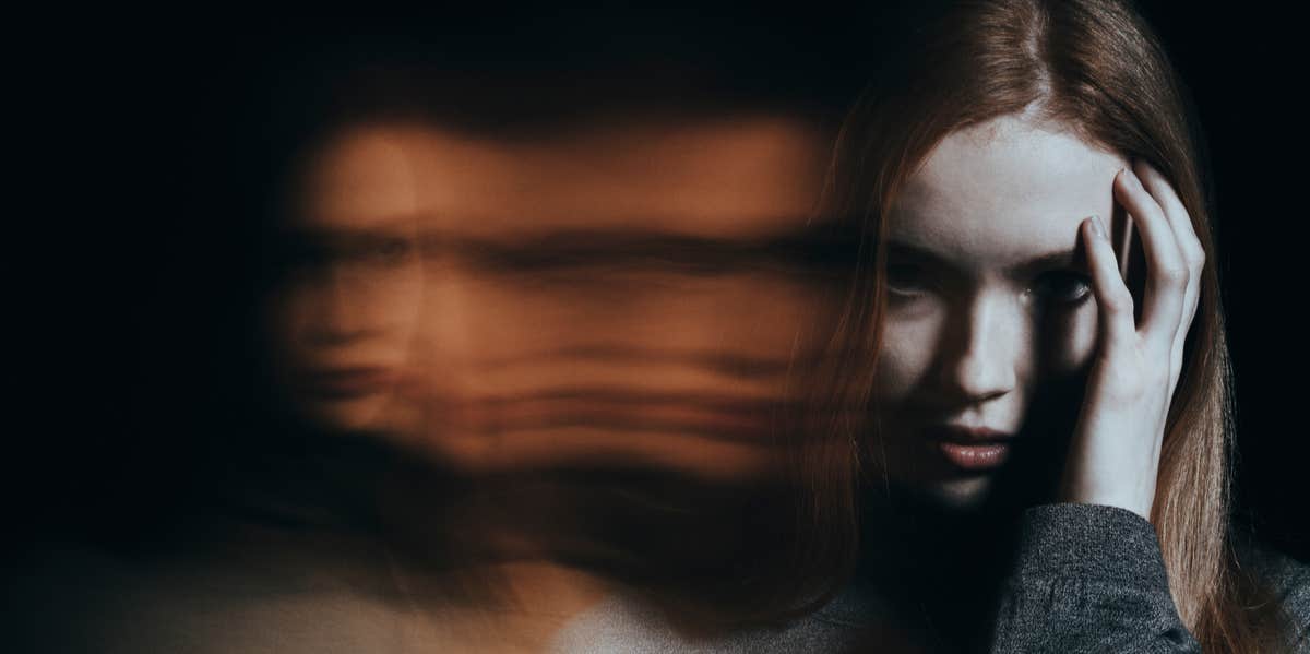 woman with hand on forehead in moody photo