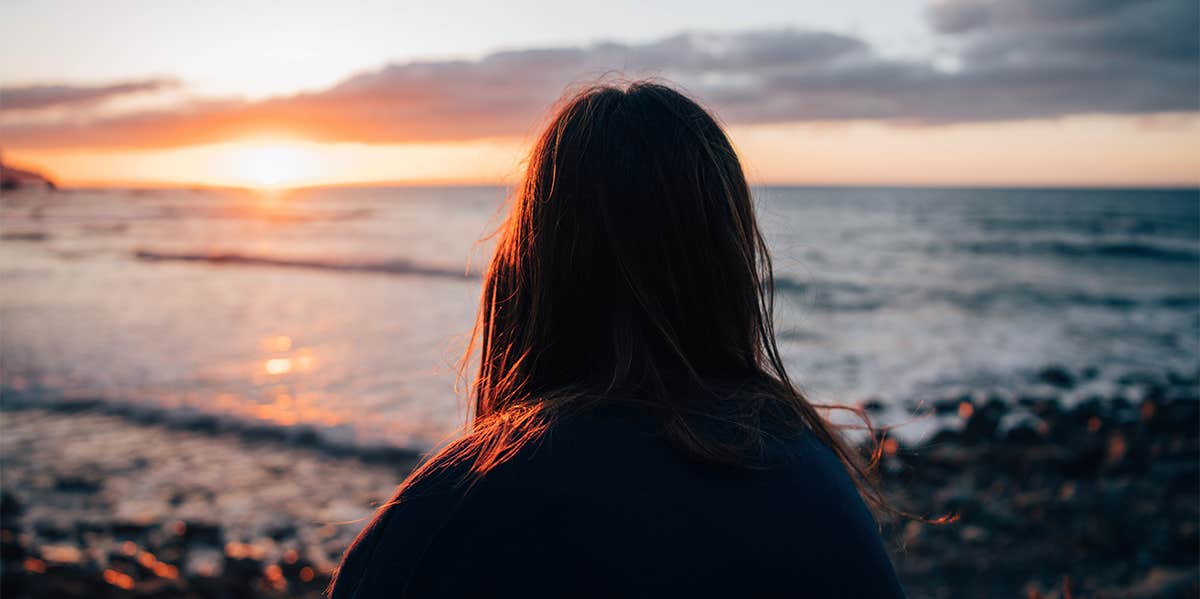 Why Your Lone Wolf Mentality Destroys Your Chance To Find Real Love girl sitting alone at beach watching sunset