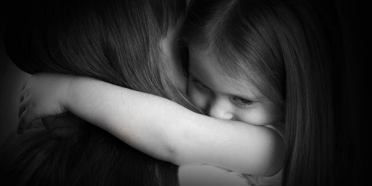 little girl crying and hugging mother