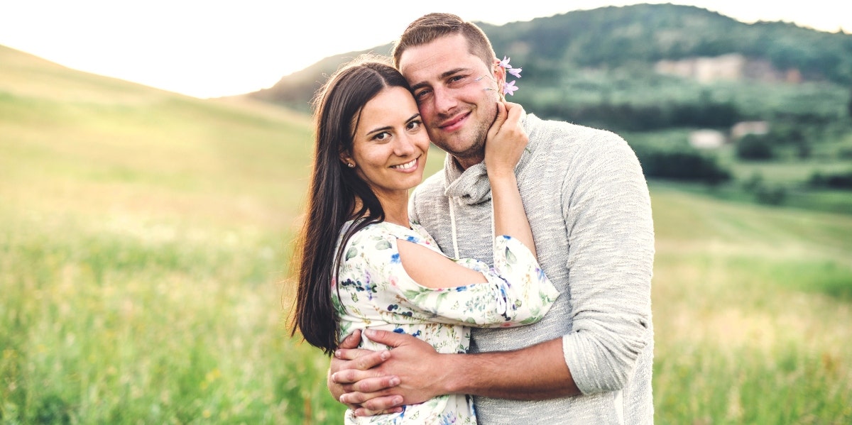 happy and loving couple in a good marriage posing on a field