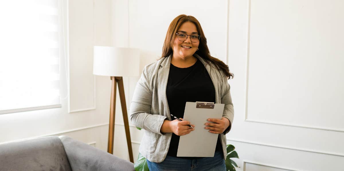 woman in glasses holding clipboard