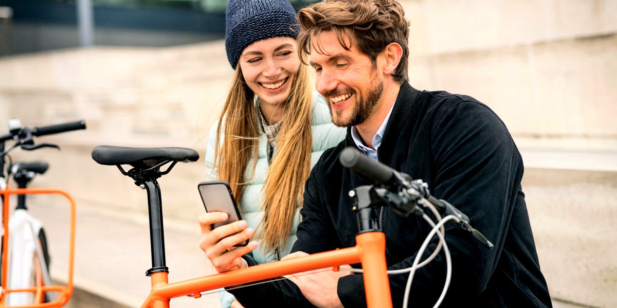 woman and man sitting together while he looks at his phone