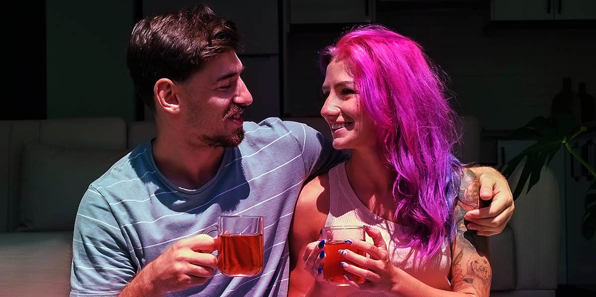 man and woman enjoying drink together on porch